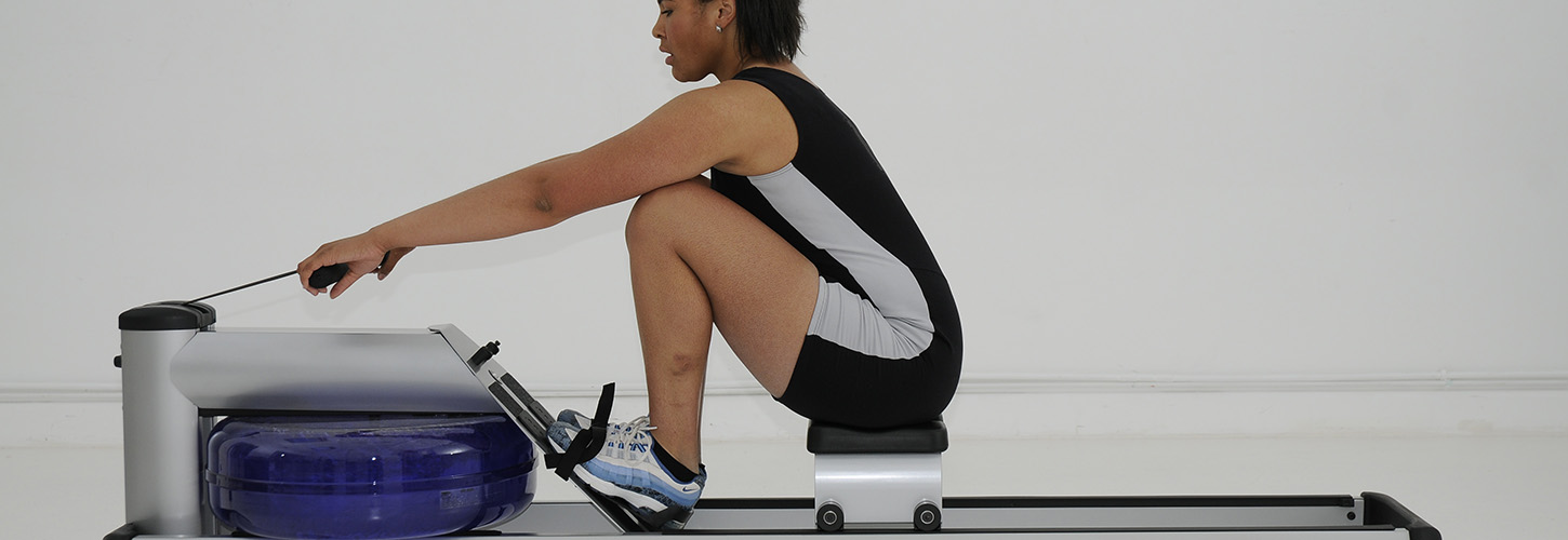 woman at catch on indoor rowing machine