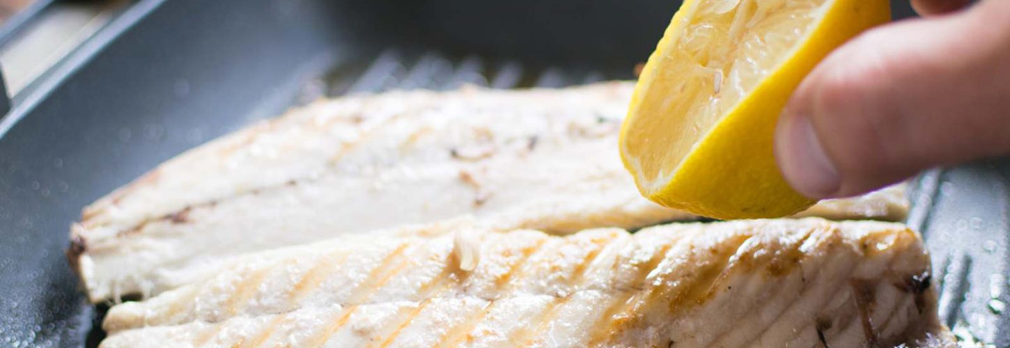 squeezing lemon juice onto mackerel