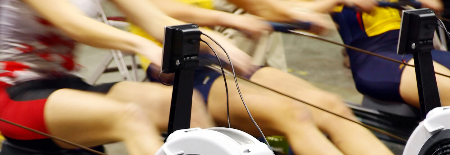 Blurred image of rowers racing on indoor machines