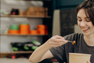 Woman eating out of cardboard tub
