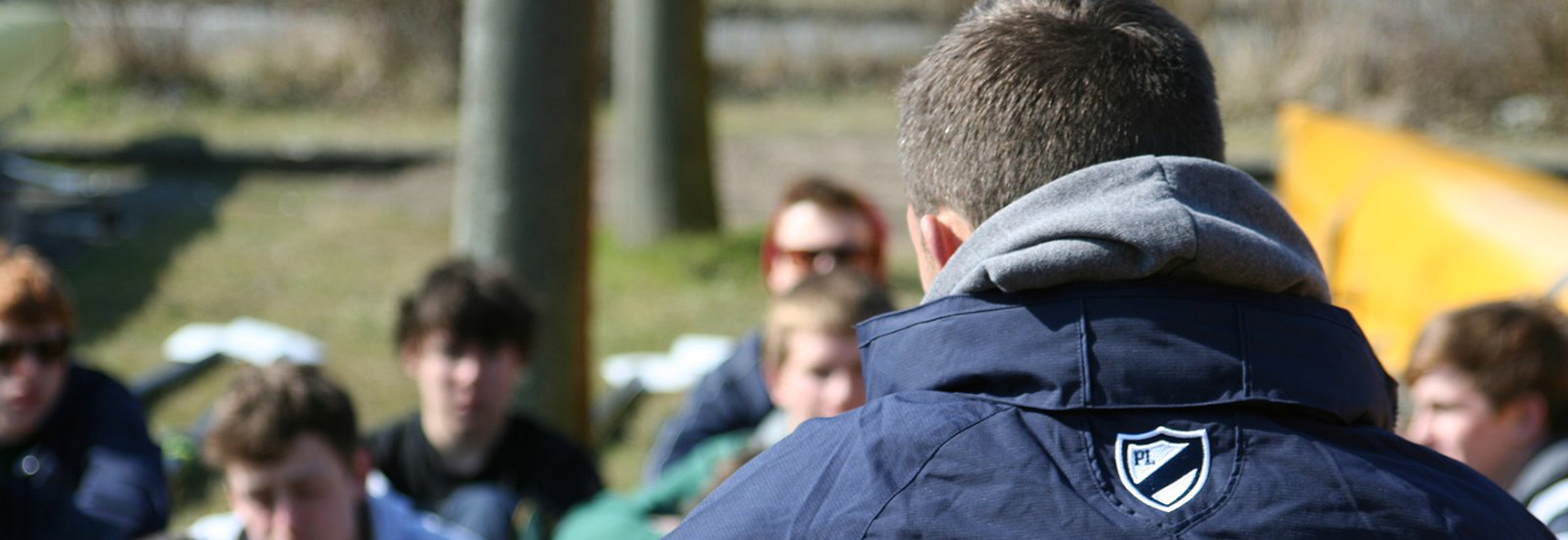 coach with young rowers at boathouse