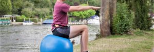 young man doing Pilates exercise on Swiss ball