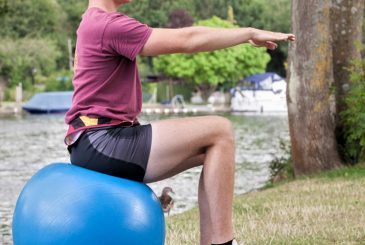 young man doing Pilates exercise on Swiss ball