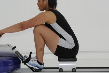 woman at catch on indoor rowing machine
