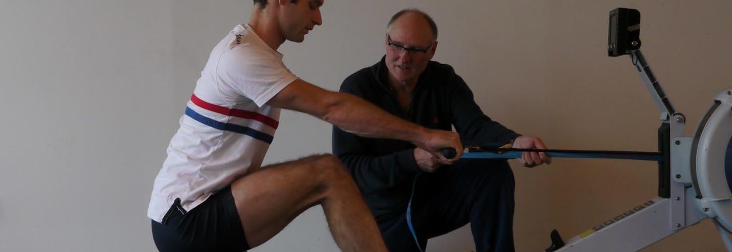 man on ergo held by boat tie with coach