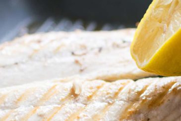 squeezing lemon juice onto mackerel