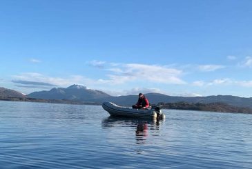 young volunteer coach in launch on lake
