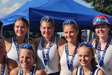 young women rowers, some in sun hats