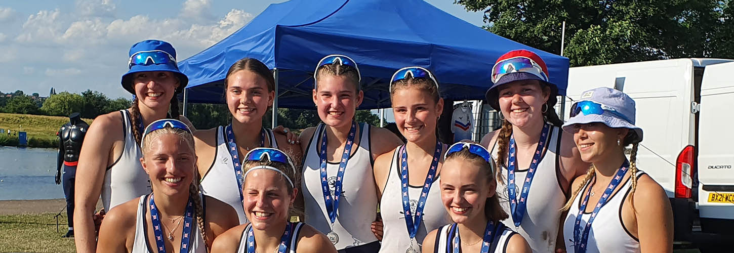 young women rowers, some in sun hats
