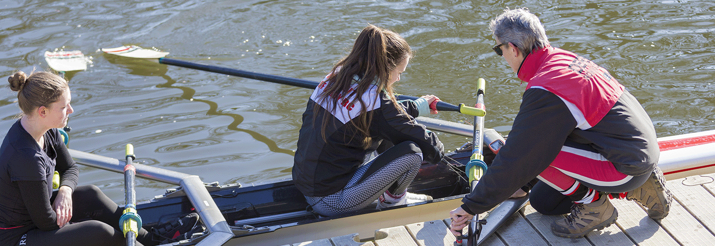 Coach helping double scull to boat