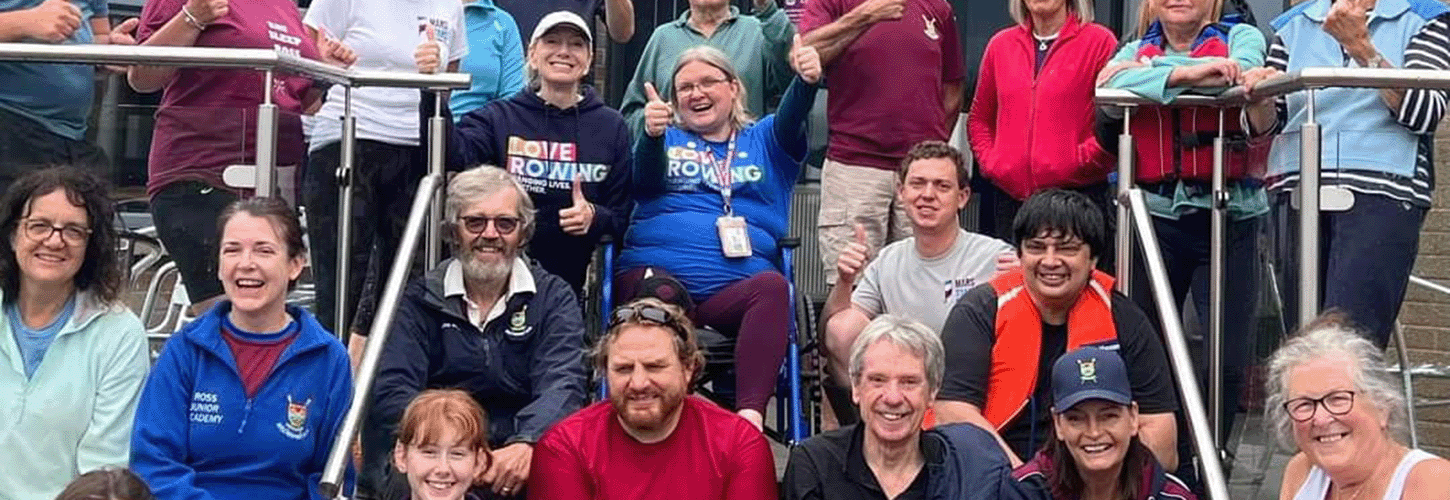 Happy mixed ability rowers sitting on steps at club