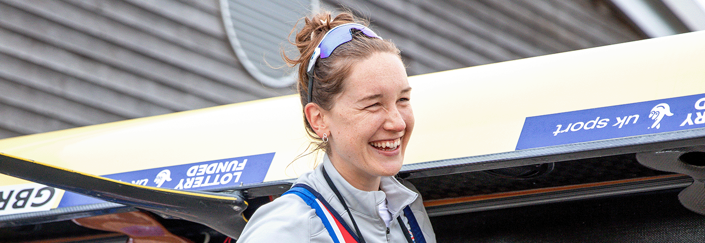 Woman wmilling while carrying a boat at the start of a training session