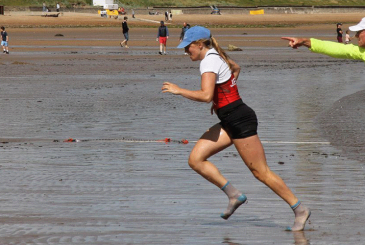 coastal sculler sprinting up beach